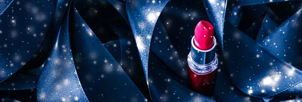 Red lipstick on blue silk and shiny glitter background, luxury make-up and beauty cosmetics