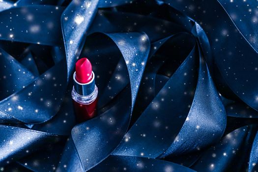 Red lipstick on blue silk and shiny glitter background, luxury make-up and beauty cosmetics