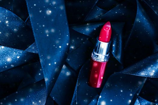 Red lipstick on blue silk and shiny glitter background, luxury make-up and beauty cosmetics