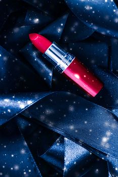 Red lipstick on blue silk and shiny glitter background, luxury make-up and beauty cosmetics