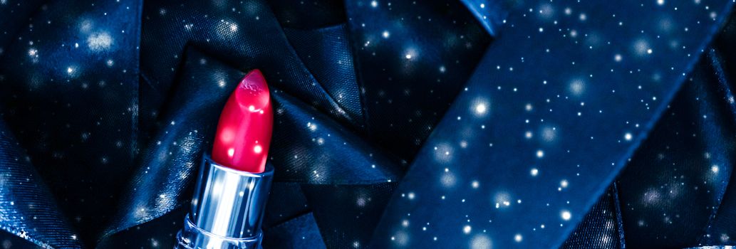 Red lipstick on blue silk and shiny glitter background, luxury make-up and beauty cosmetics