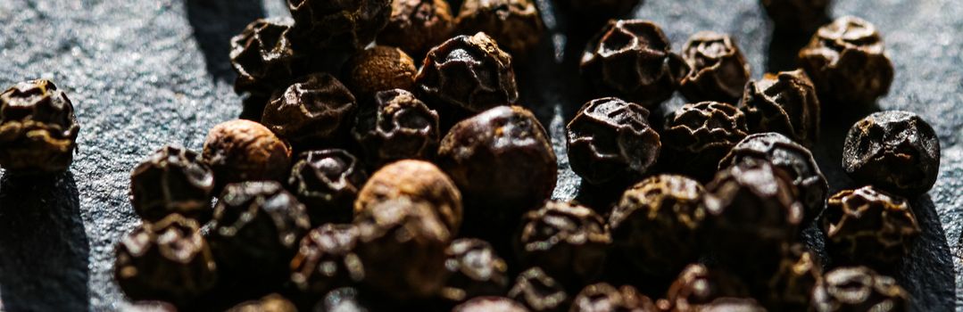 Black pepper closeup on luxury stone background as flat lay, dry food spices and recipe ingredients