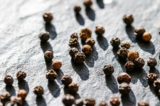 Black pepper closeup on luxury stone background as flat lay, dry food spices and recipe ingredients