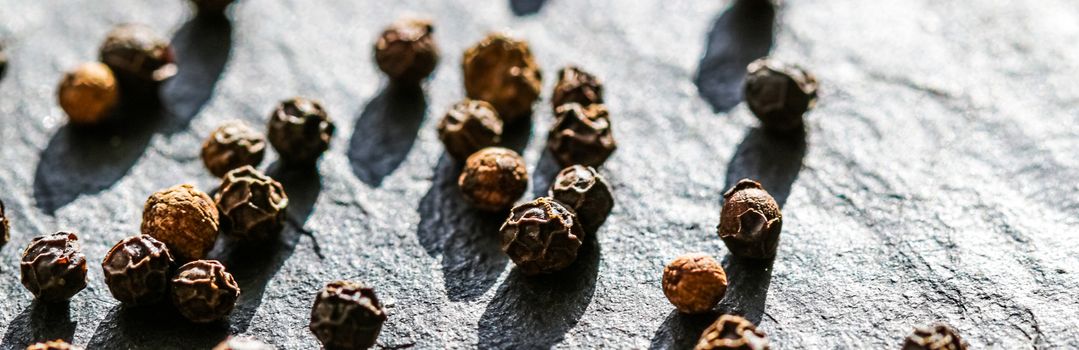 Black pepper closeup on luxury stone background as flat lay, dry food spices and recipe ingredients