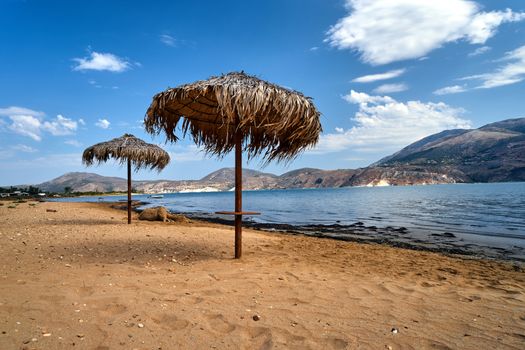 Umbrellas on an empty sandy beach on Kefalonia island in Greece