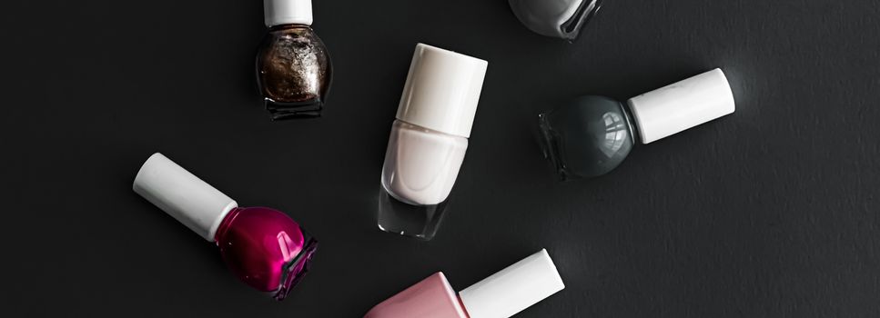 Nail polish bottles on black background, beauty branding