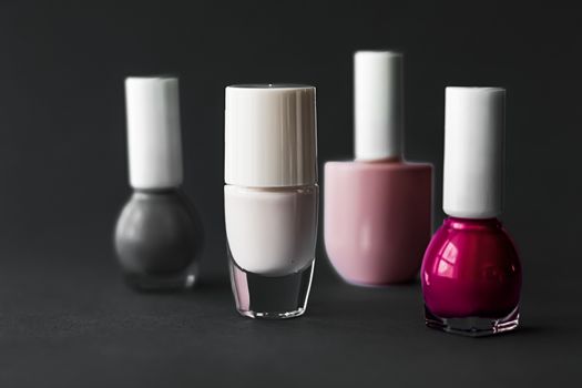 Nail polish bottles on black background, beauty branding