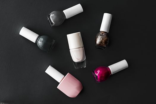 Nail polish bottles on black background, beauty branding