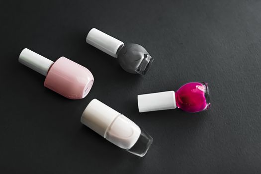 Nail polish bottles on black background, beauty branding