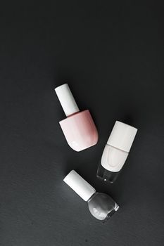 Nail polish bottles on black background, beauty branding