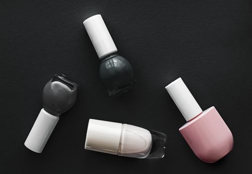 Nail polish bottles on black background, beauty branding