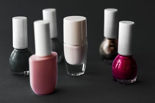 Nail polish bottles on black background, beauty branding