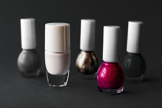 Nail polish bottles on black background, beauty branding