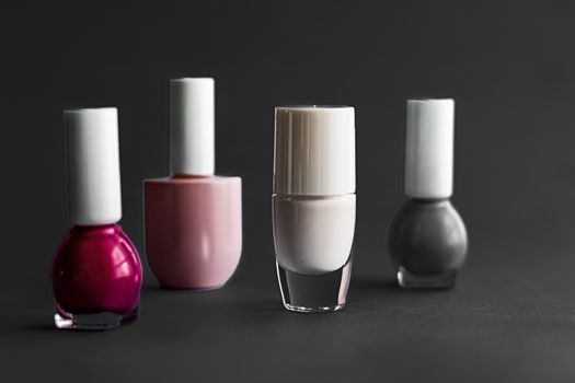 Nail polish bottles on black background, beauty branding