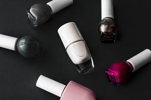 Nail polish bottles on black background, beauty branding