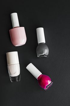 Nail polish bottles on black background, beauty branding