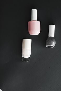 Nail polish bottles on black background, beauty branding