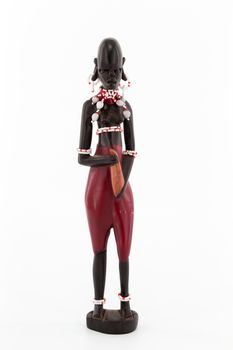 A wooden figure of a Maasai women on white background