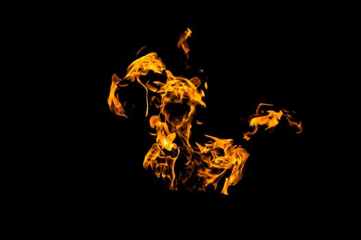 Fire flames on black background isolated. Burning gas or gasoline burns with fire and flames. Flaming burning sparks close-up, fire patterns. Infernal glow of fire in the dark with copy-space