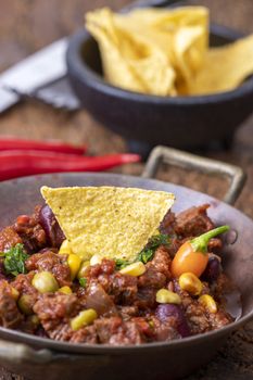 tasty chili con carne on wood