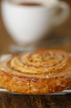pastry roll with cappucino on wood