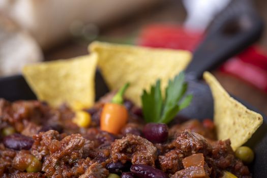 tasty chili con carne on wood