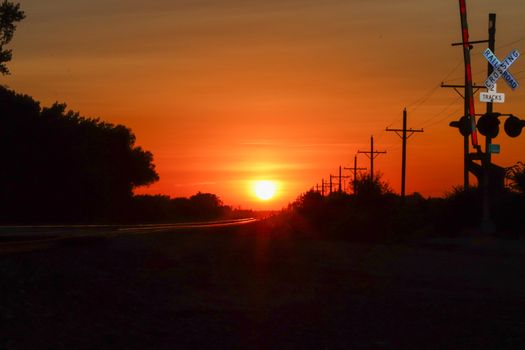 Rail Road crossing and tracks at sunset . High quality photo