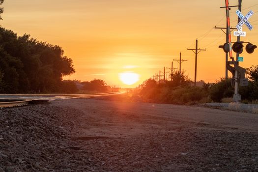 Rail Road crossing and tracks at sunset . High quality photo