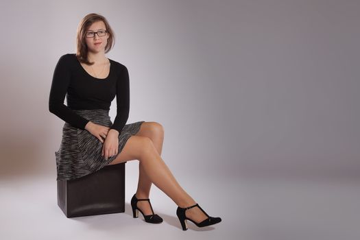 Young woman is sitting on a stool