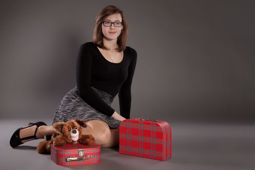 A young girl with suitcases and a soft toy