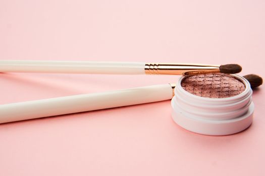 makeup brushes and eyeshadow professional cosmetics on pink background. High quality photo