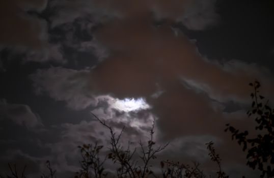 Full moon in night mystic sky with clouds