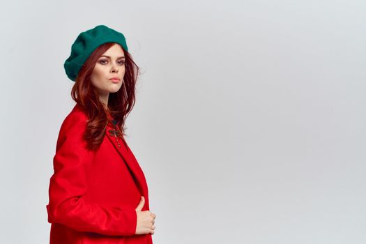 Woman in red coat and in green hat on isolated background cropped model with Copy Space emotions. High quality photo