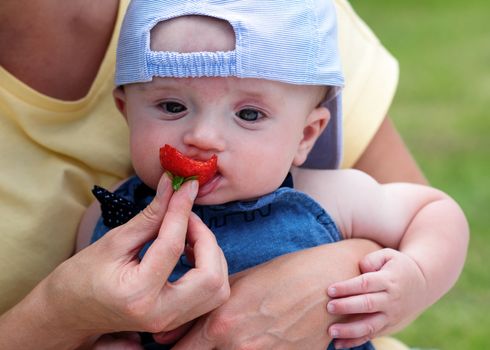 a child grabbing strawberries from a bowl