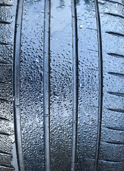 Black big tires in a close up view with water drops. Tire tread problems. Solutions concept.