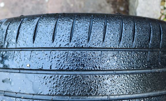 Black big tires in a close up view with water drops. Tire tread problems. Solutions concept.