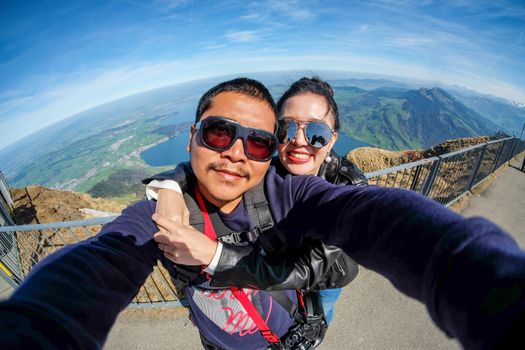 Young Couple Tourists selfie with mobile phone near view of Rigi mountain in Switzerland with a magnificent panoramic view of Swiss alps