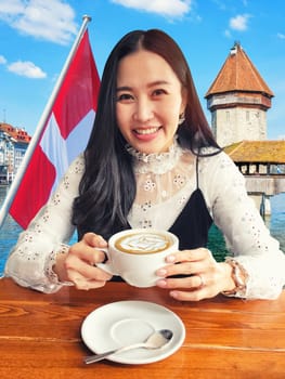 Portrait of young beauty enjoying her coffee on Luceren city background, Switzerland