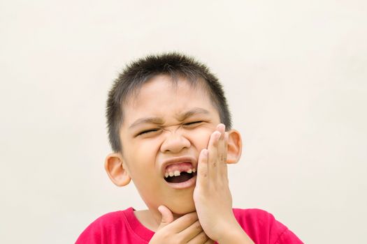 Close up in front of a boy singing in pain because of toothache.