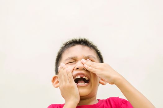 Close up in front of a boy singing in pain because of toothache.