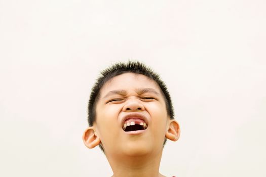 Close up in front of a boy singing in pain because of toothache.