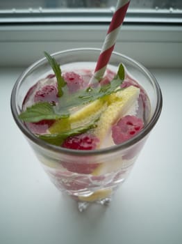 Summer Refreshing cocktail of natural fruits and various berries with ice and mint leaves infused with water. Contains lemon, raspberry, cherry, gooseberry, red currant.