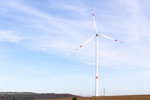 The windmill on a field with blue sky