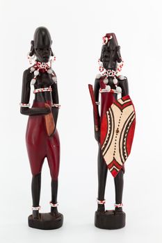Some wooden figure of a couple of Maasai on white background