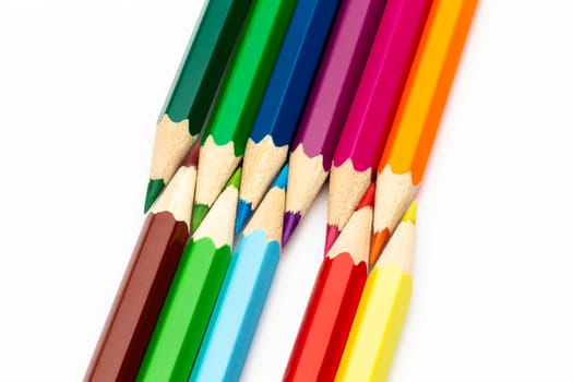 A wooden colored pencils of different colors on a white background