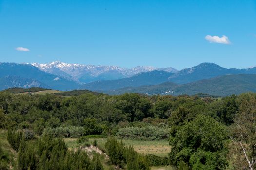 A landscape shot with green forests, mountains and a blue sky