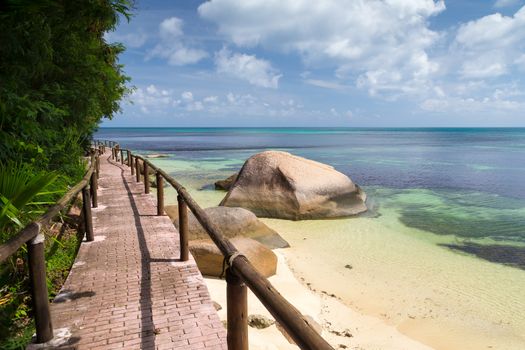 Pathway by the ocean with big stones and green plants