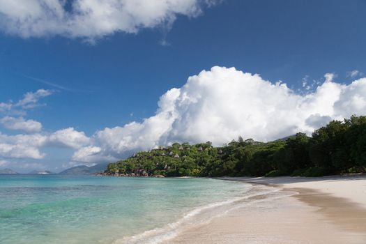 A beach on the Seychelles island with white sand and stones