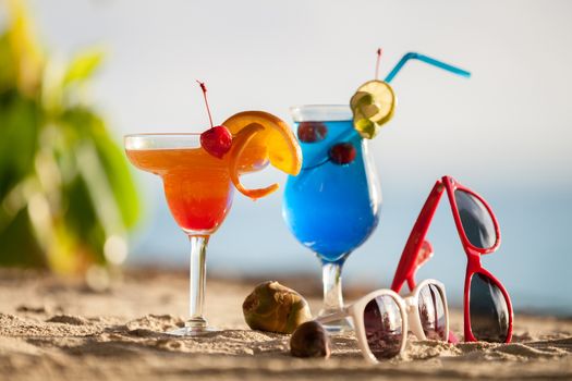 colorful cocktails standing on the sand