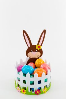 Some Colorful Easter eggs in a basket with an Easter bunny